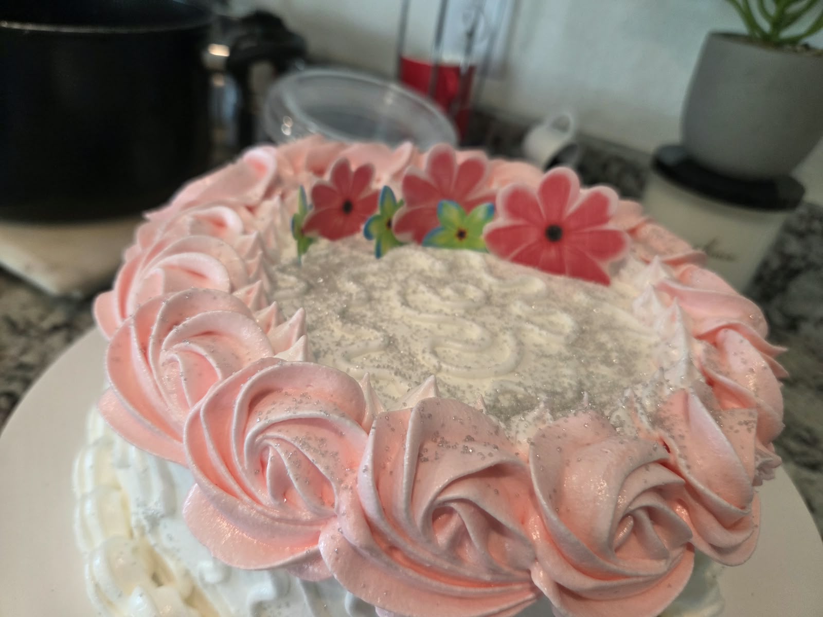 Cake decorado con flores y mariposas sobre una superficie clara